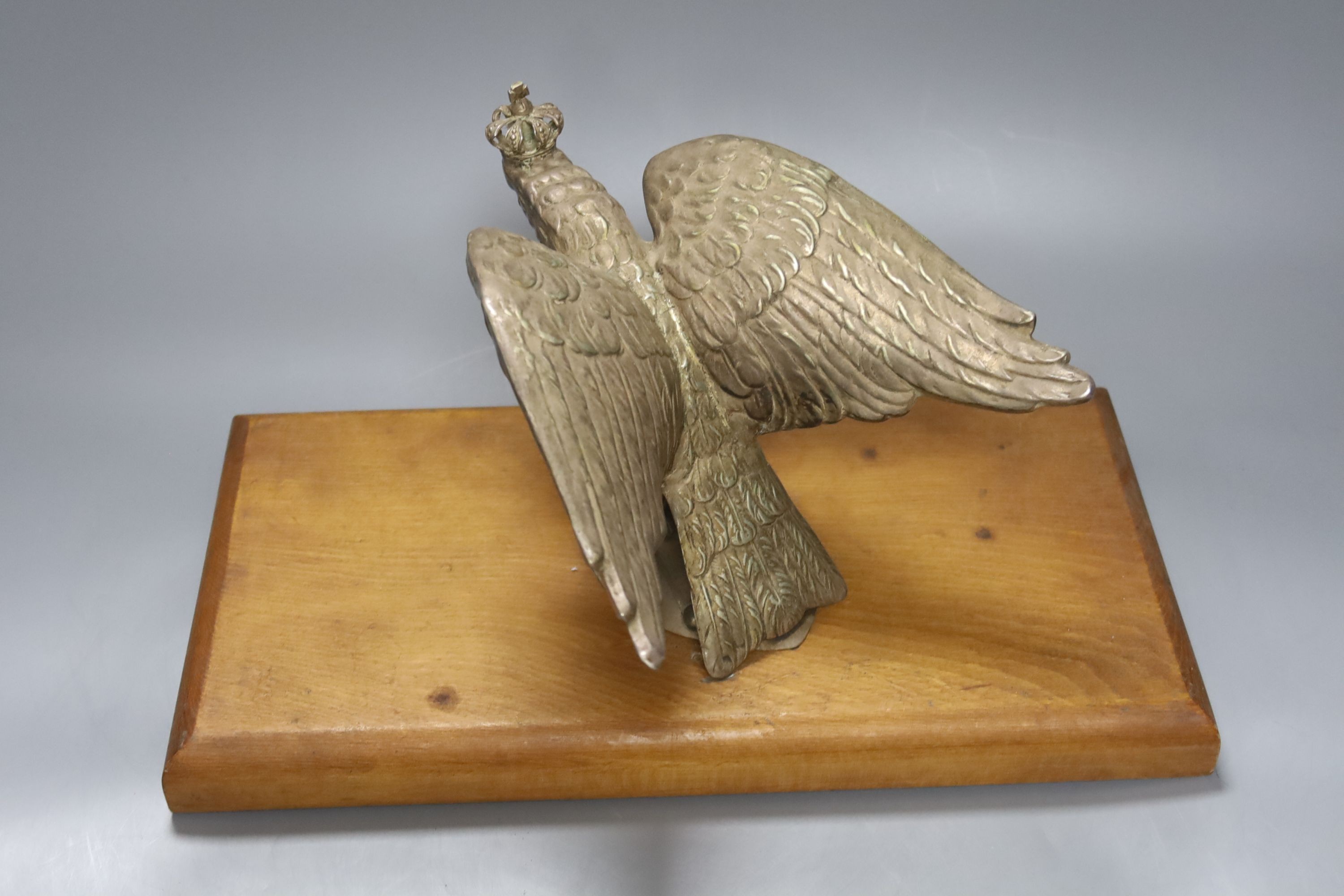 A plated Prussian eagle finial for a Prussian Guard’s helmet, later wood plinth, W36cm